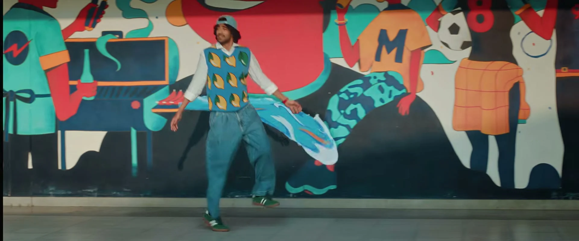 Vivasvaan standing before a colourful mural